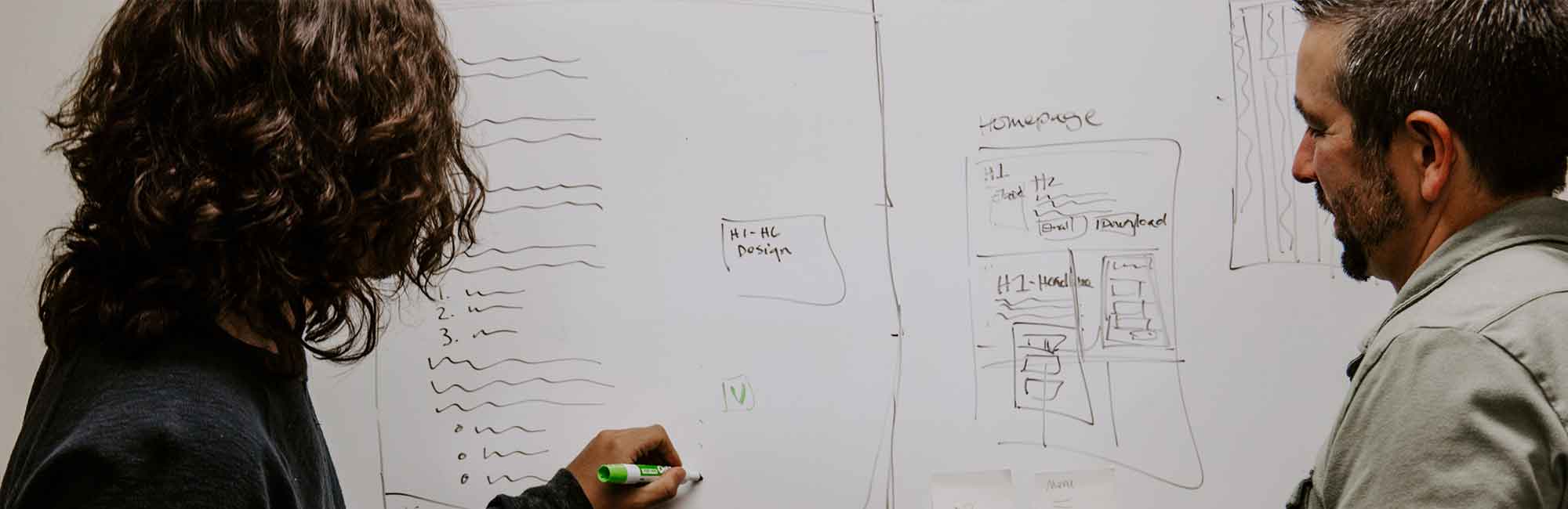 a woman with a man draw on a blackboard