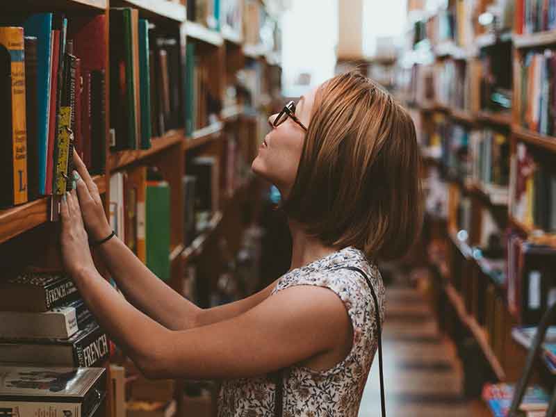  a student looks for a book in the library